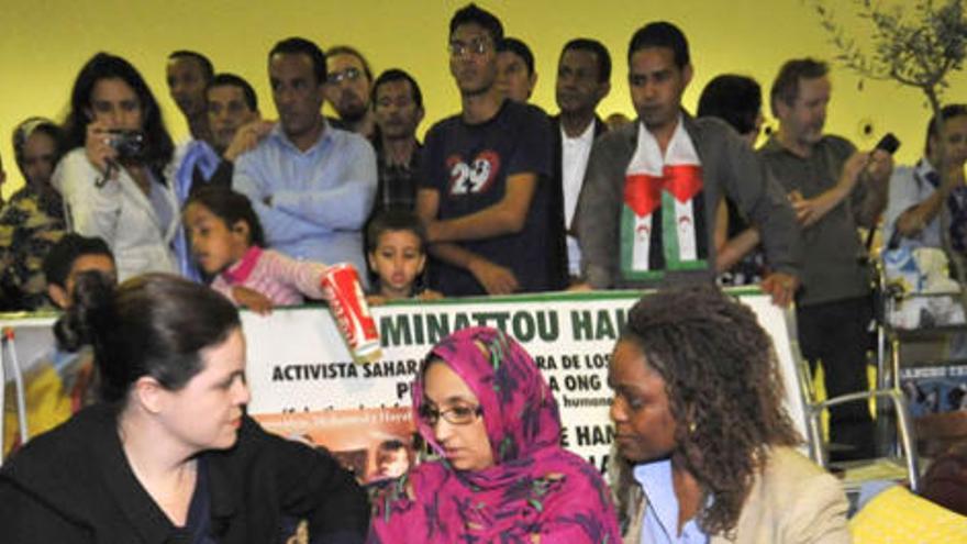 Dos representantes de la Fundación Robert Kennedy, que le concedió un premio a Aminatu Haidar hace tres semanas en Nueva York, brindan a la activista su apoyo en el Aeropuerto de Lanzarote.