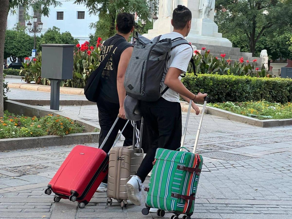 Turistas en Sevilla con maleta y equipaje durante su visita a la ciudad