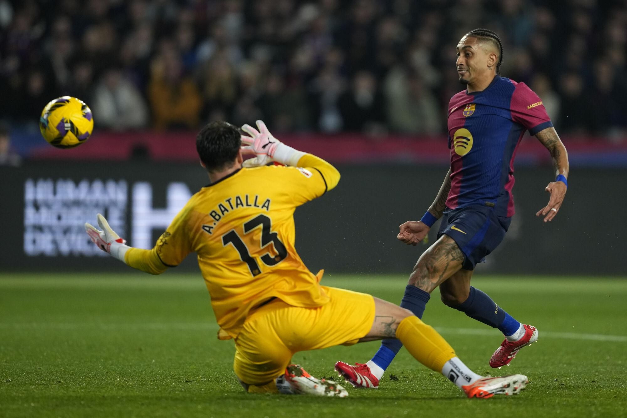 FC Barcelona's Raphinha (R) in action against Rayo Vallecano's goalkeeper Augusto Batalla (L) during the Spanish LaLiga soccer match between FC Barcelona and Rayo Vallecano in Barcelona, Spain, 17 February 2025. EFE/ Alejandro García