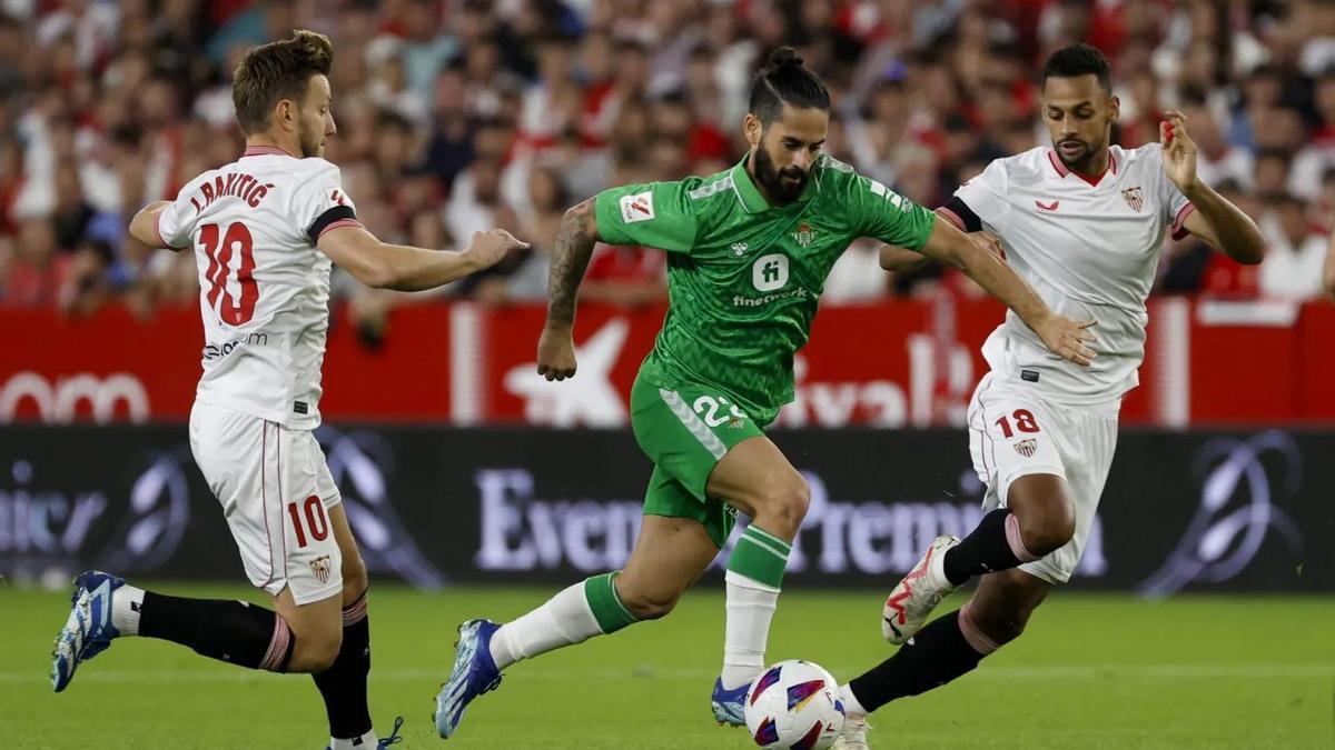 Isco Alarcón juega un balón entre Ivan Rakitic y Djibril Sow durante el derbi sevillano