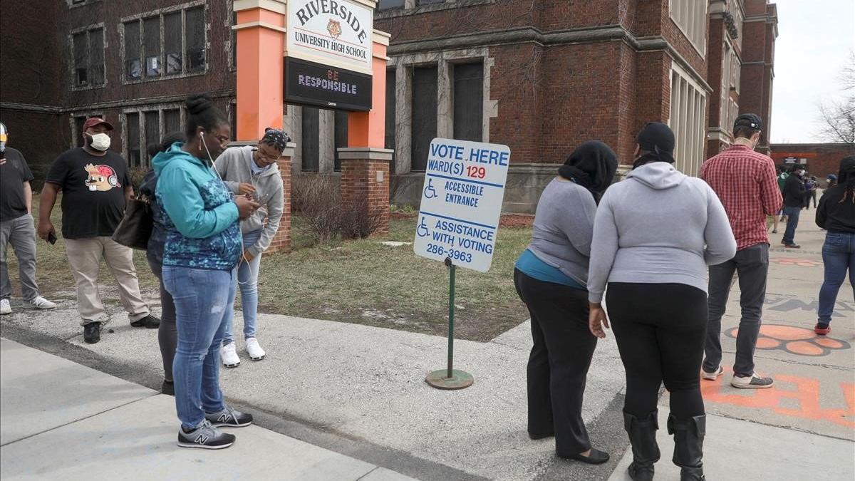 Votantes hacen cola en los alrededores de la Universidad Riverside, en el marco de las elecciones primarias presidenciales celebradas en medio del brote del covid-19, en Milwaukee, Wisconsin.