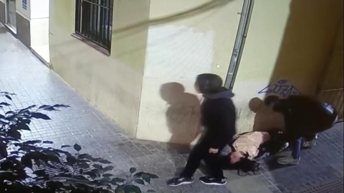 Momento en el que la joven vigila mientras su compañero intenta desvalijar a la víctima, ya inconsciente.