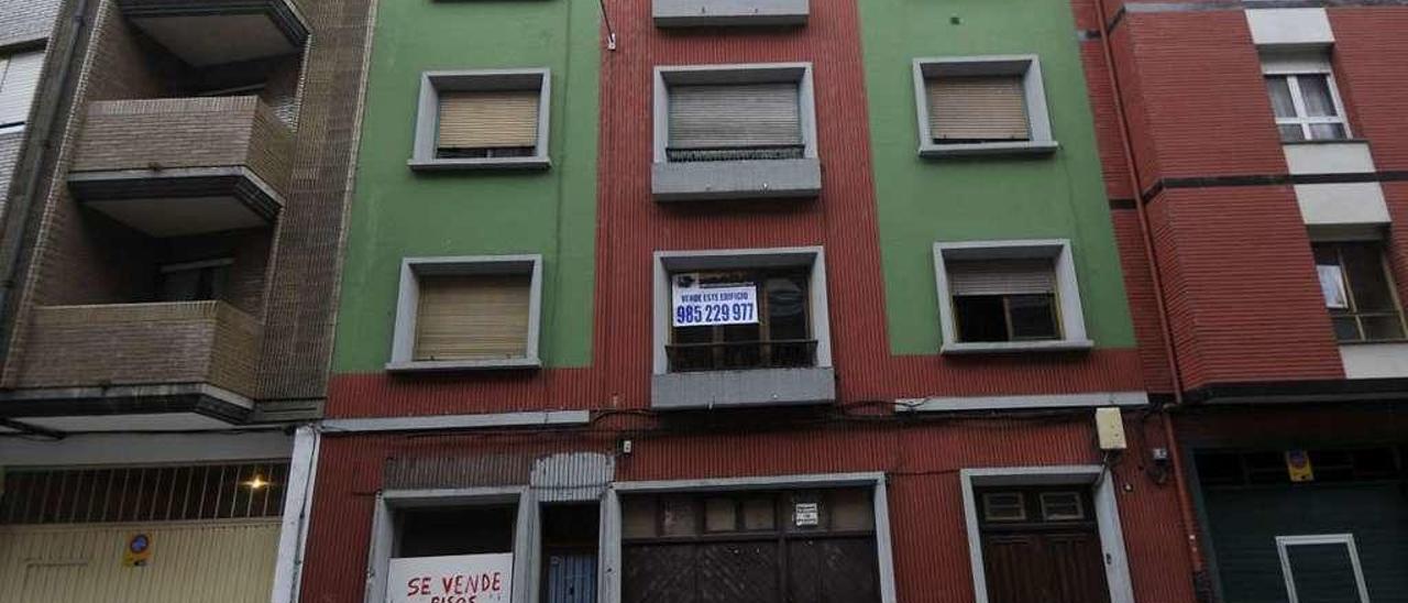 Un edificio de la calle Antonio Lucio Villegas, en Sama, con un cartel de venta al completo.