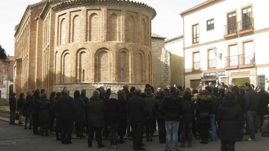 Participantes en la visita siguen las explicaciones de la guía sobre la iglesia de San Lorenzo. Foto
