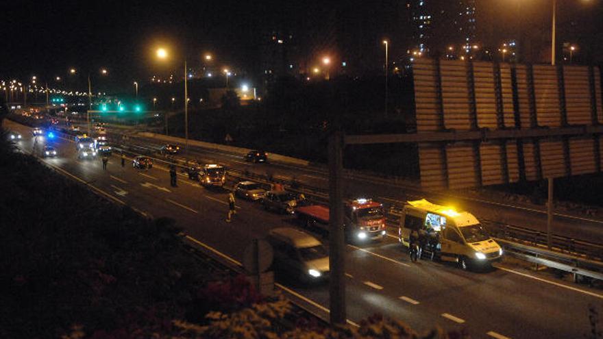 Vista general del lugar del accidente, con la mujer herida dentro de la ambulancia.