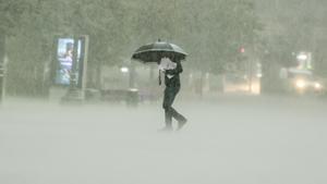 Un hombre camina bajo la lluvia intensa