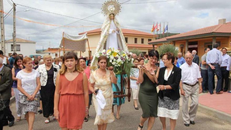 Las mujeres llevan en andas a la patrona durante la procesión por las calles de Litos, que congregó a numerosos hijos del pueblo.