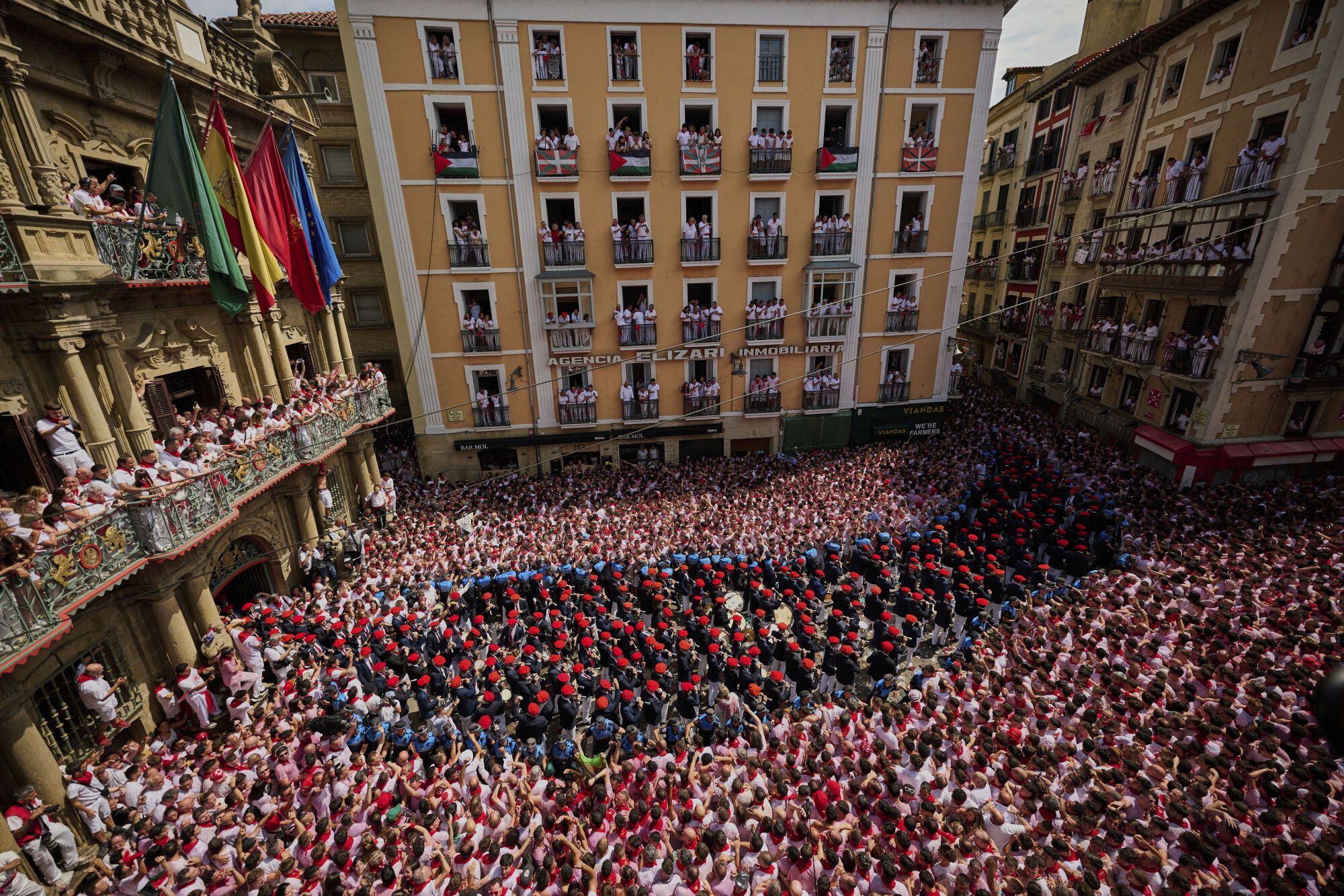 A municipal music band makes it's way through the crowd as revelers pack the main square during the start of nine days of uninterrupted partying in Pamplona's famed running-of-the-bulls festival in Pamplona, Spain, Sunday, July 6, 2025. (AP Photo/Miguel Oses). EDITORIAL USE ONLY/ONLY ITALY AND SPAIN