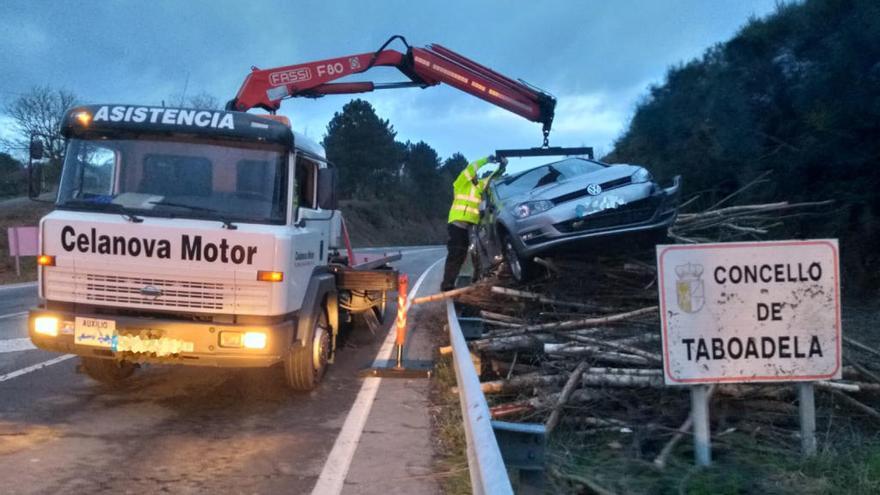 Una grúa tuvo que bajar el coche de encima de los troncos // GC