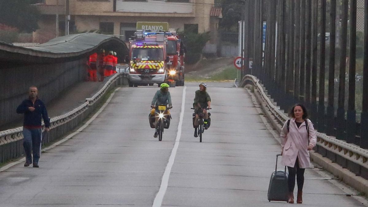 Los bomberos arreglan las planchas del puente de Catoira, que solo estuvo abierto para peatones y ciclistas. |   // IÑAKI ABELLA