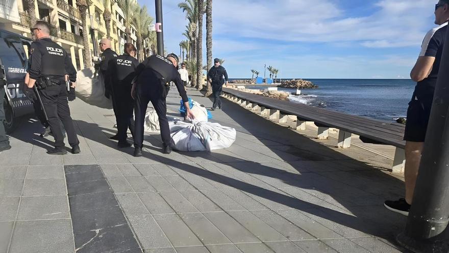 Un policía local desenfunda su arma de fuego para reducir a un hombre que rajó las cuatro ruedas de un coche patrulla en el paseo de Torrevieja