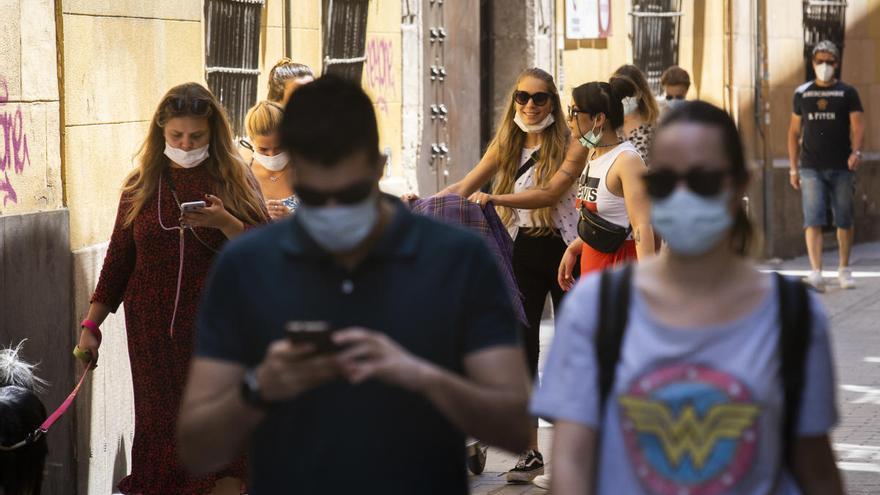 Varias personas con mascarilla por Valencia.