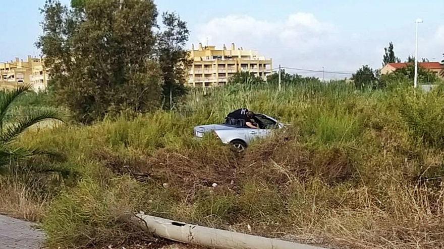 Estado en que quedó el coche, en el marjal, con una de las farolas que rompió.