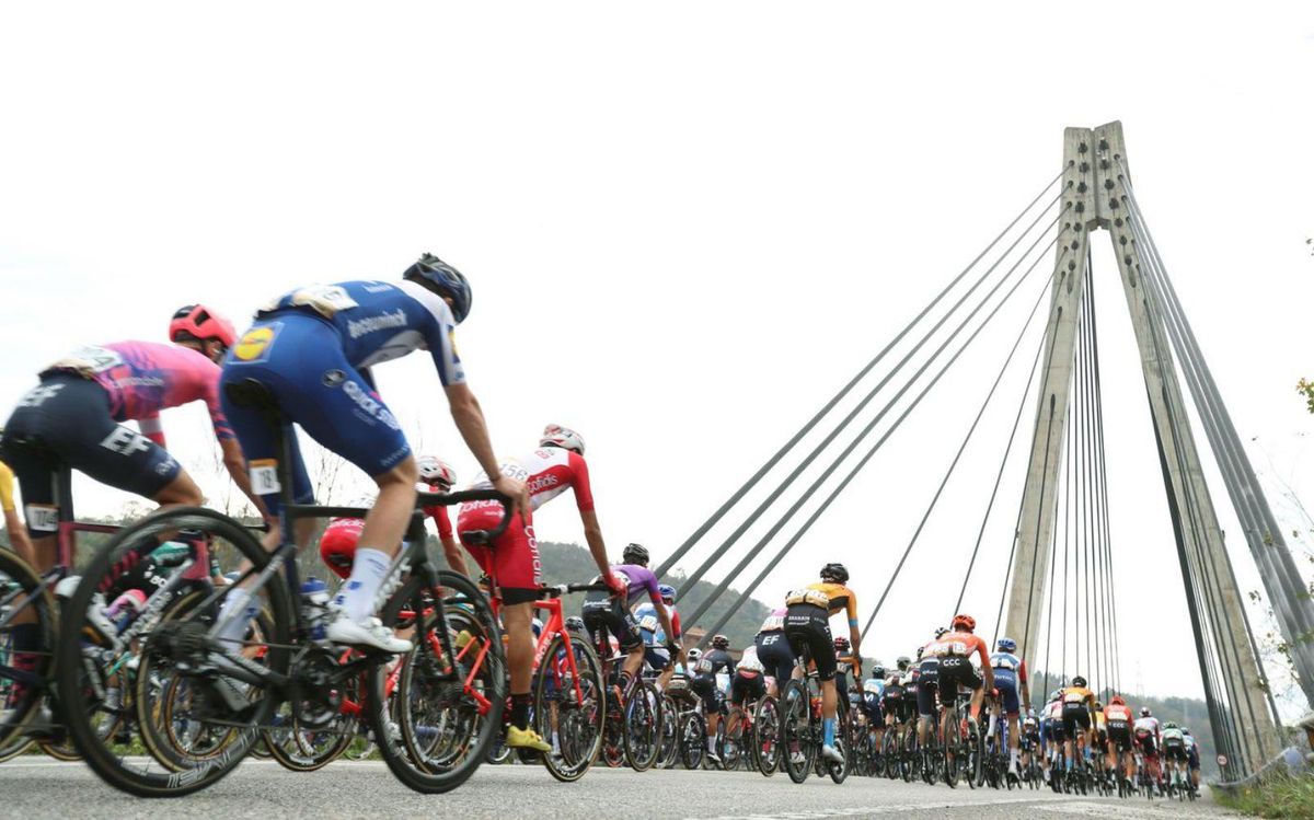 Los ciclistas pasan por el puente atirantado de Langreo. | EFE