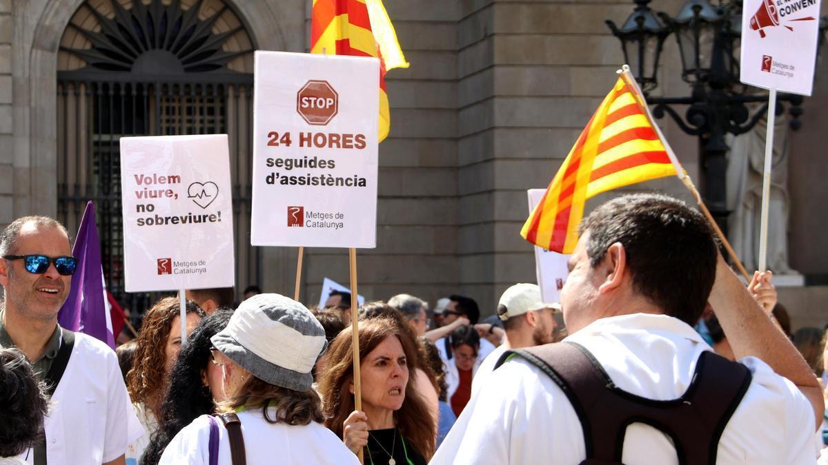 Metges protesten a la plaça de Sant Jaume de Barcelona amb pancartes contra les guàrdies de 24 hores i altres reivindicacions, en una jornada de vaga del col·lectiu