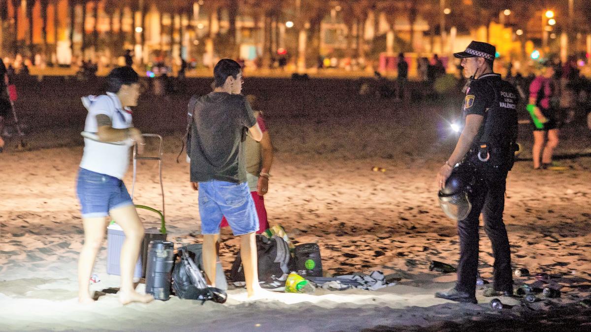 Un agente enfoca a unos jóvenes en la pasada noche de San Juan