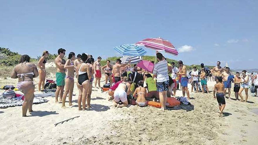 Varias personas atienden al turista danés, anteayer en una playa de Muro.