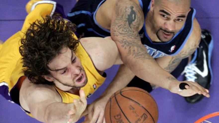 El jugador español de los Lakers de Los Angeles Pau Gasol marca a su rival   Carlos Boozer, de los Jazz de Utah, en la primera mitad del juego de la NBA que se disputa en el Staples Center de Los Angeles, California.