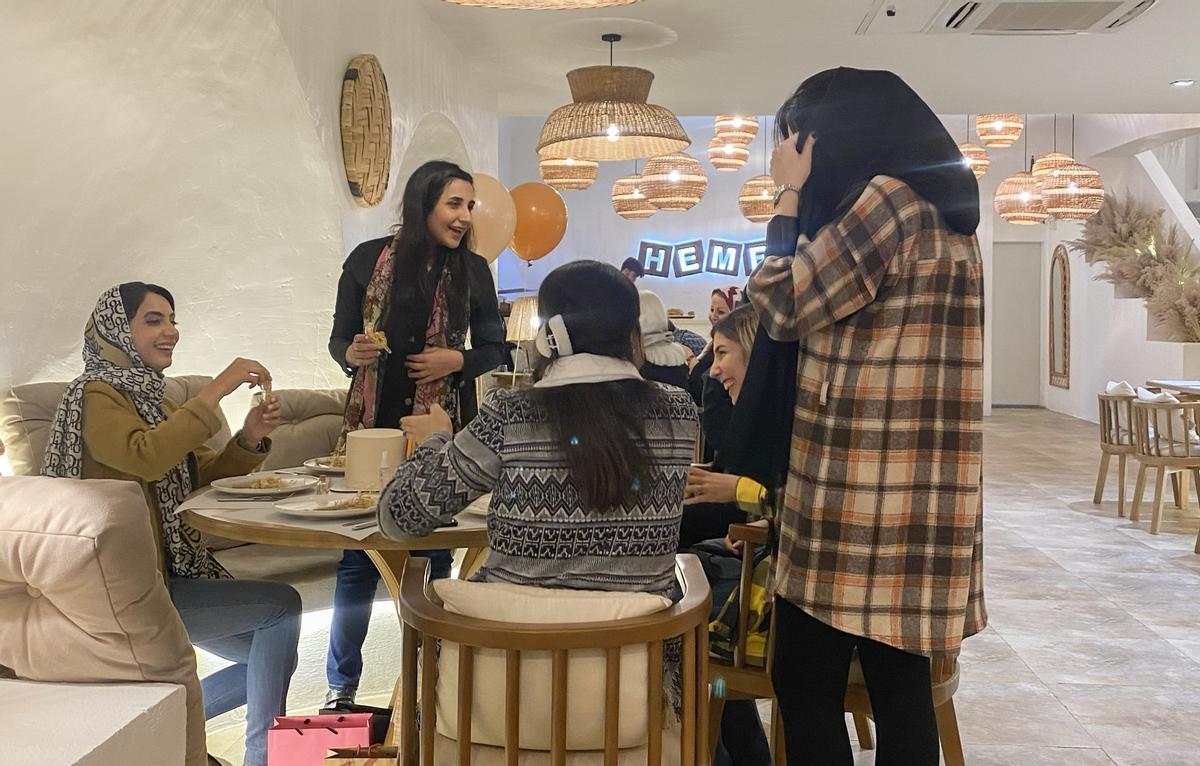 Chicas en un restaurante de Teherán en el que un cartel indicaba la obligatoriedad del uso del velo.