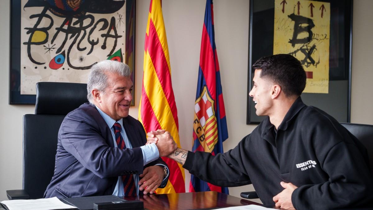 Joao Cancelo firmó su contrato al lado del presidente Laporta