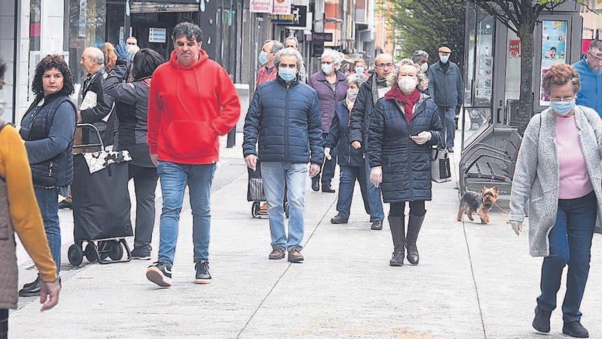 Varias personas paseando con mascarilla por la calle Barcelona.