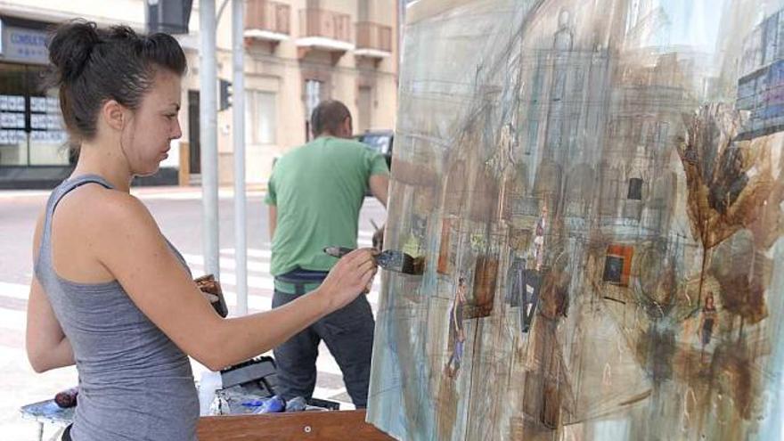 Una pintora participante en el certamen plasma el ir y venir de gente en la plaza de la Constitución.