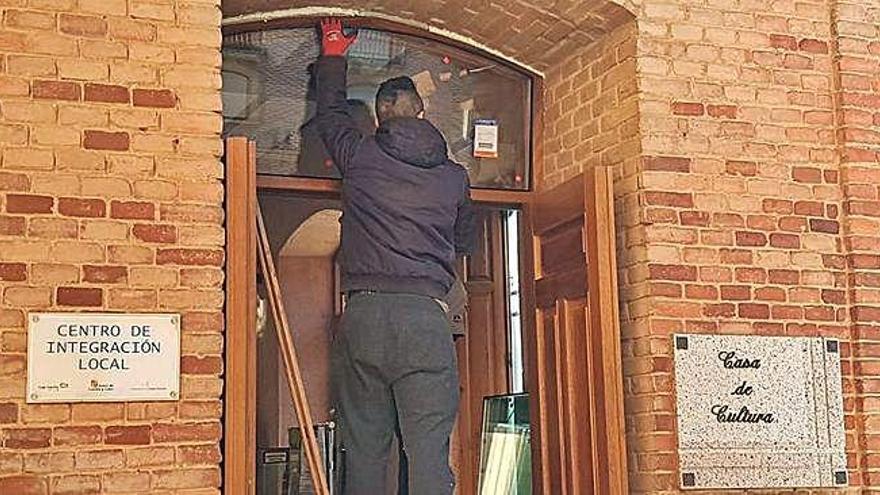 Un trabajador ajusta la vidriera del acceso principal a La Encomienda.