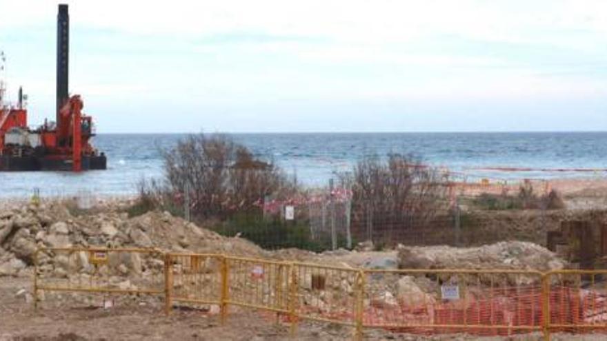 Imagen de las obras y al fondo, una embarcación dragando la zona marina de la desembocadura.