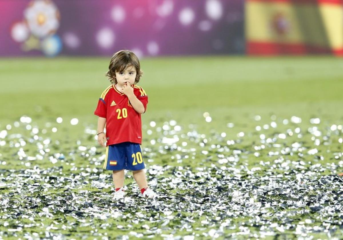 El hijo del jugador español Santi Cazorla, en el campo, disfruta del confeti.