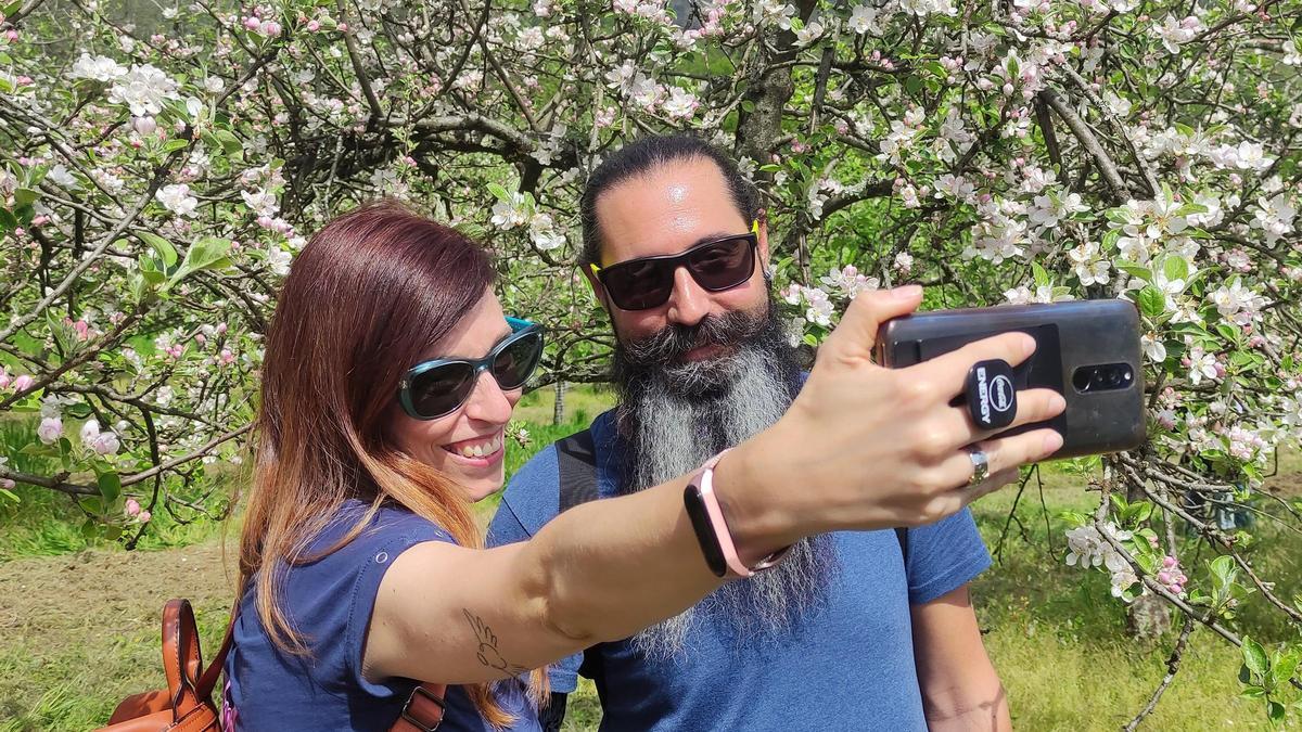 Una pareja se hace un selfi con los manzanos en flor