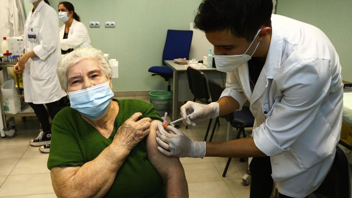 Una mujer recibe la dosis de refuerzo del coronavirus y de la gripe en el Centro de Salud de Bombarda. | JAIME GALINDO
