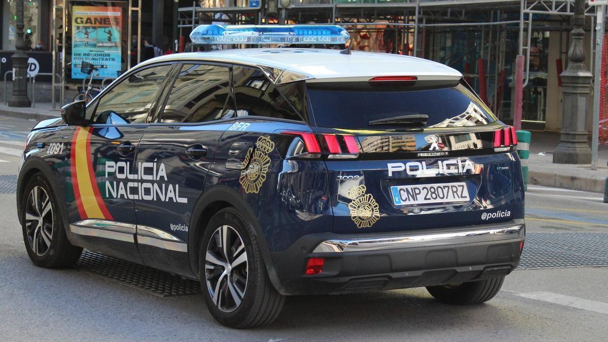 Un vehículo de la Policía Nacional circulando junto a un edificio en obras, en una imagen de archivo.