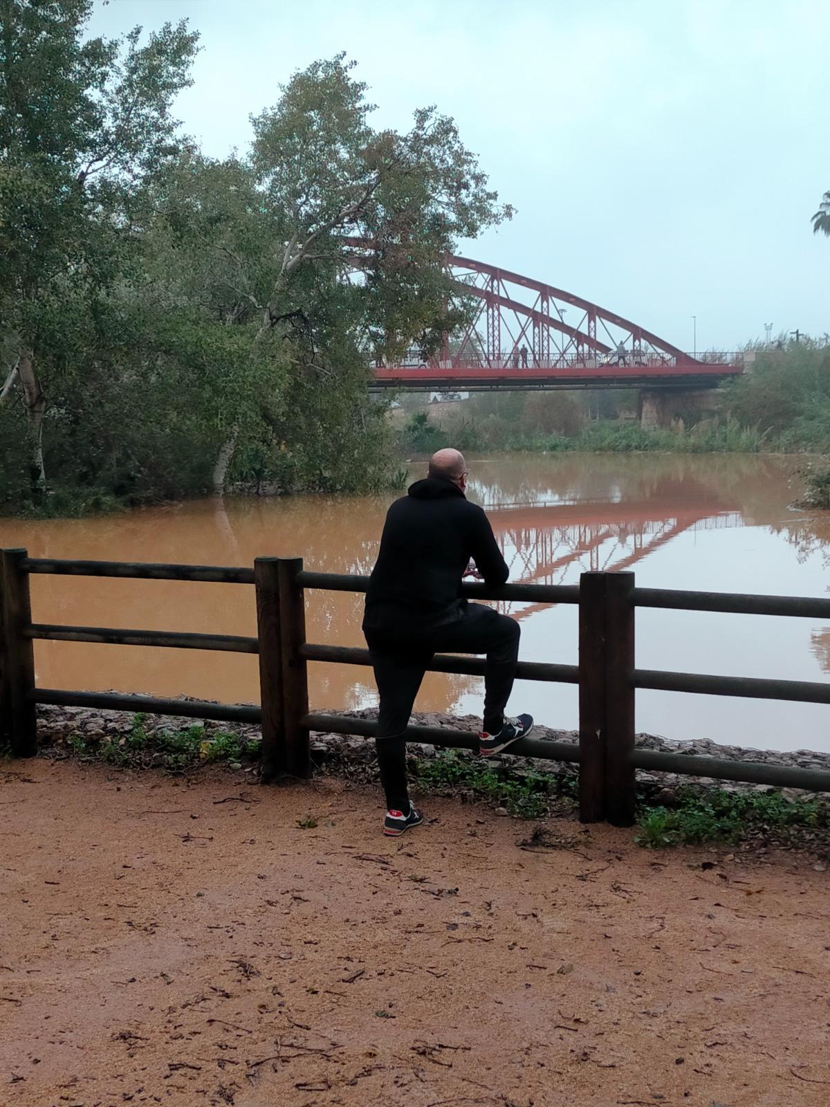 Un vecino observa una crecida del Xúquer a la altura del Pont de Ferro de Alzira, en una imagen de archivo.