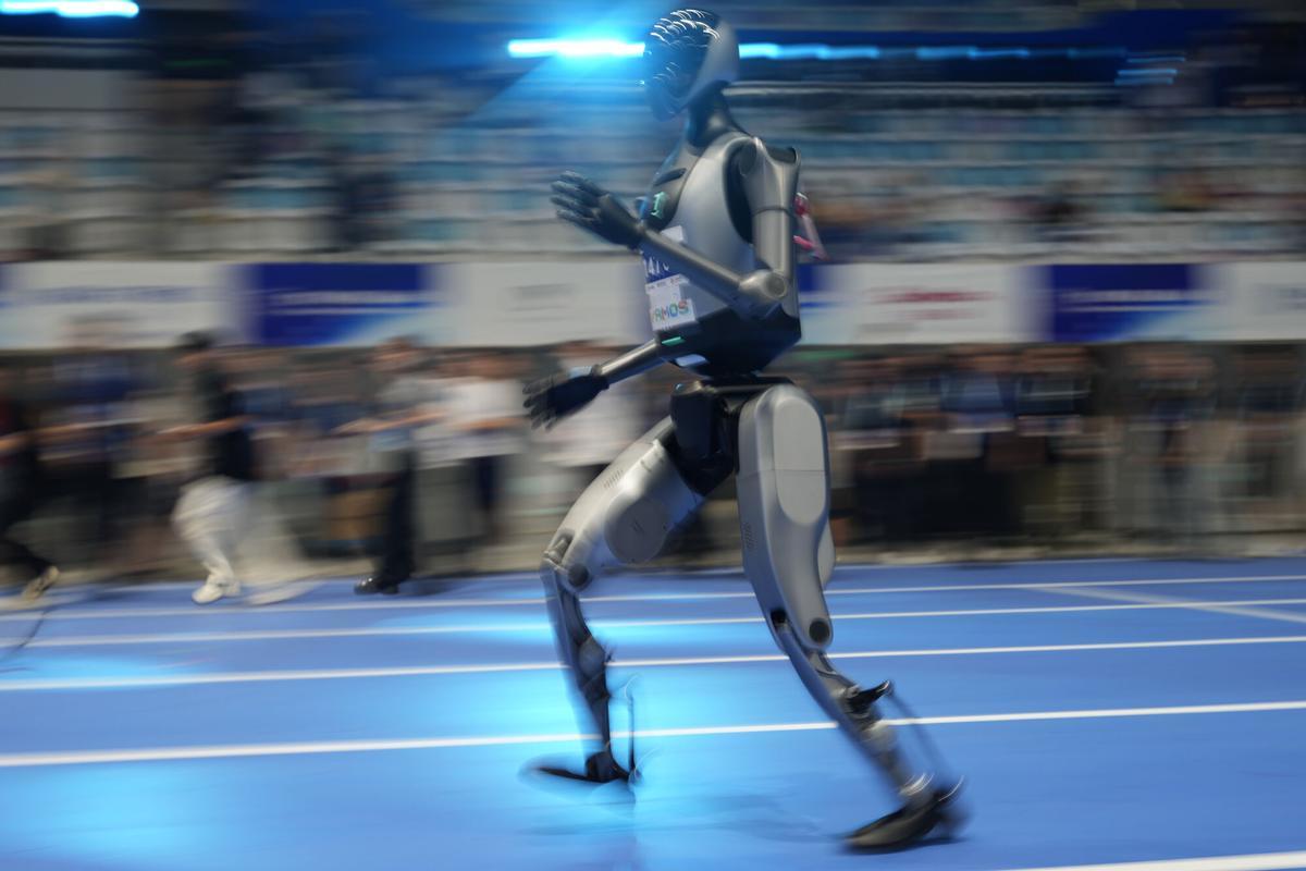 Un robot humanoide se prepara para su carrera de 100 metros antes del inicio de la ceremonia de apertura de los Juegos Mundiales de Robots Humanoides en Pekín, China, el 14 de agosto de 2025. (AP Photo/Ng Han Guan)