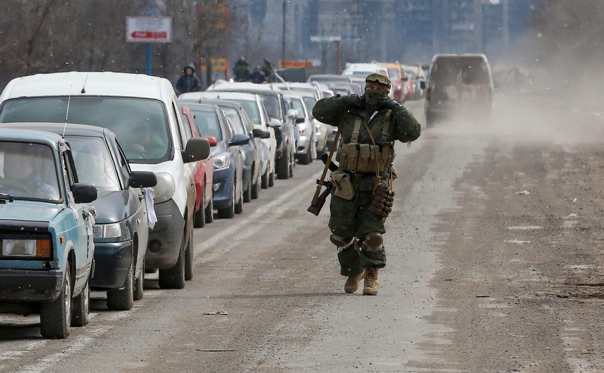 Un soldado de fuerzas prorrusas observa el convoy que intenta salir de Mariúpol, este jueves.