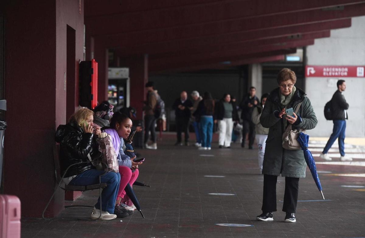 Pasajeros esperando por buses en la dársena de salidas, este viernes. |  Carlos Pardellas