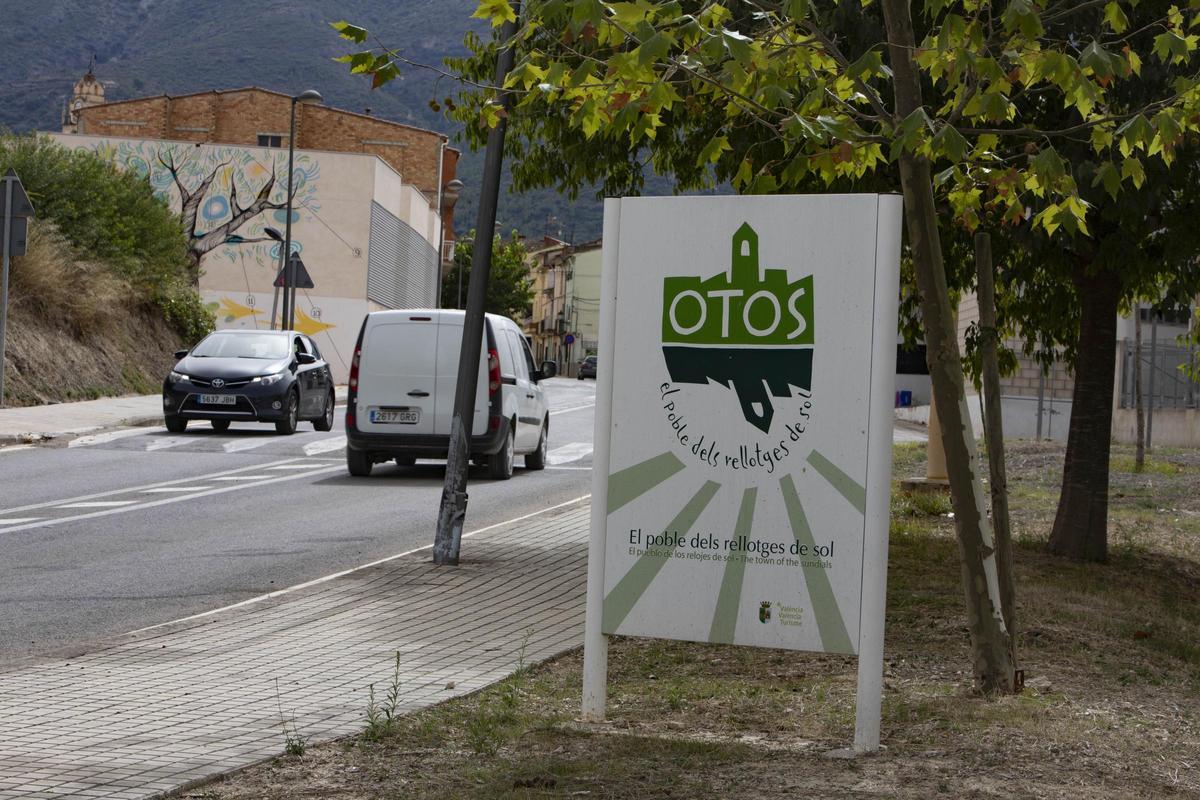 Entrada a Otos con el cartel que distingue al pueblo por los relojes de sol.
