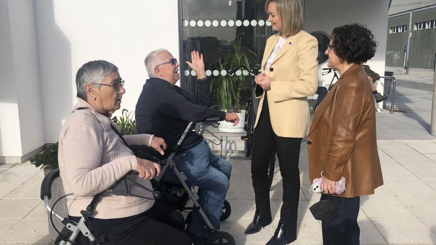 Francisca Gómez, derecha, y Fabiola García, conversando con usuarios de la residencia de A Pobra. suso souto