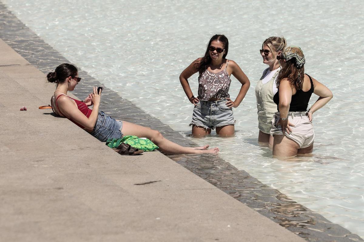 - Unas jóvenes se refrescan en una fuente este lunes en la ciudad de Valencia. EFE/Ana Escobar