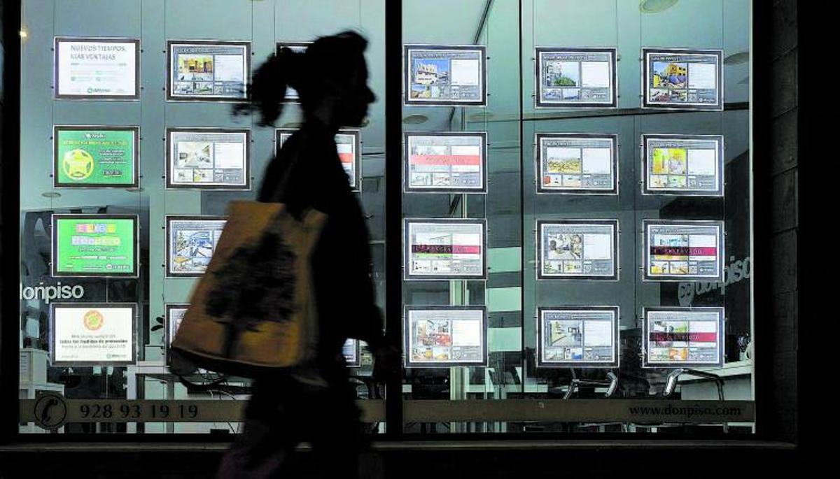 Escaparate con anuncios de casas en venta y alquiler.