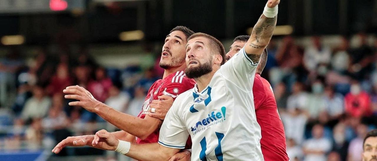 El futbolista del CD Tenerife Sipcic disputa un balón por alto en un partido de Segunda División en el Heliodoro Rodríguez López.