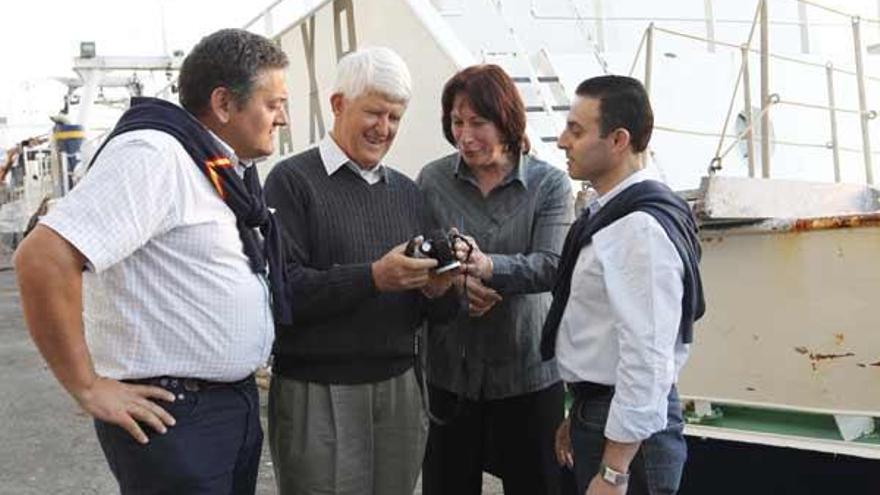 Dennis y Barbara Gregory, en el centro, reciben su cámara Nikon de manos de Benito Estévez (dcha.) y Fernando García (izqda.).  // R. Grobas
