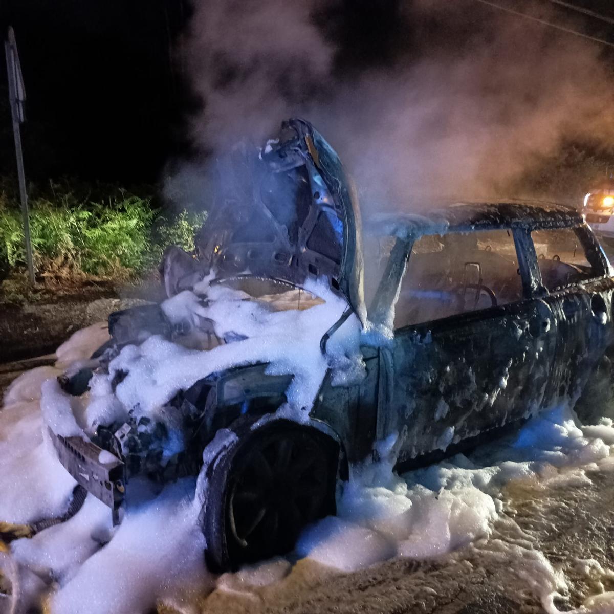 El vehículo calcinado anoche en Oleiros tras un choque contra otro turismo.