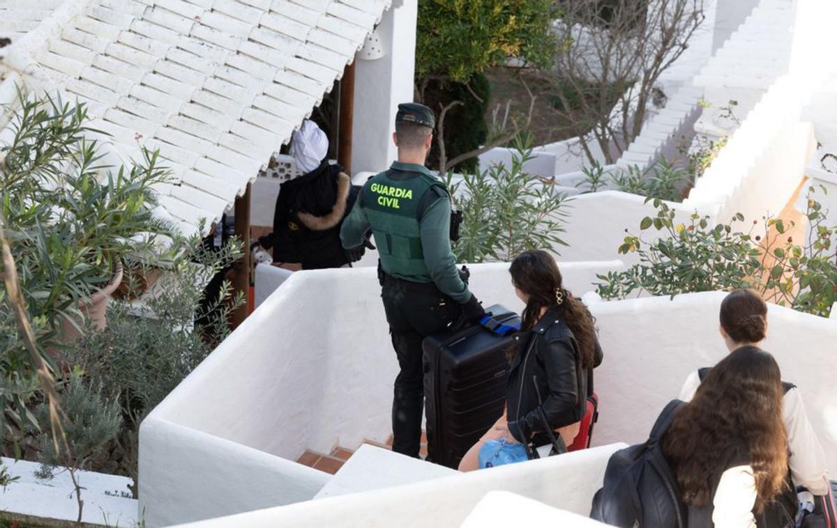 Un guardia civil le lleva la maleta a una inquilina. | VICENT MARÍ