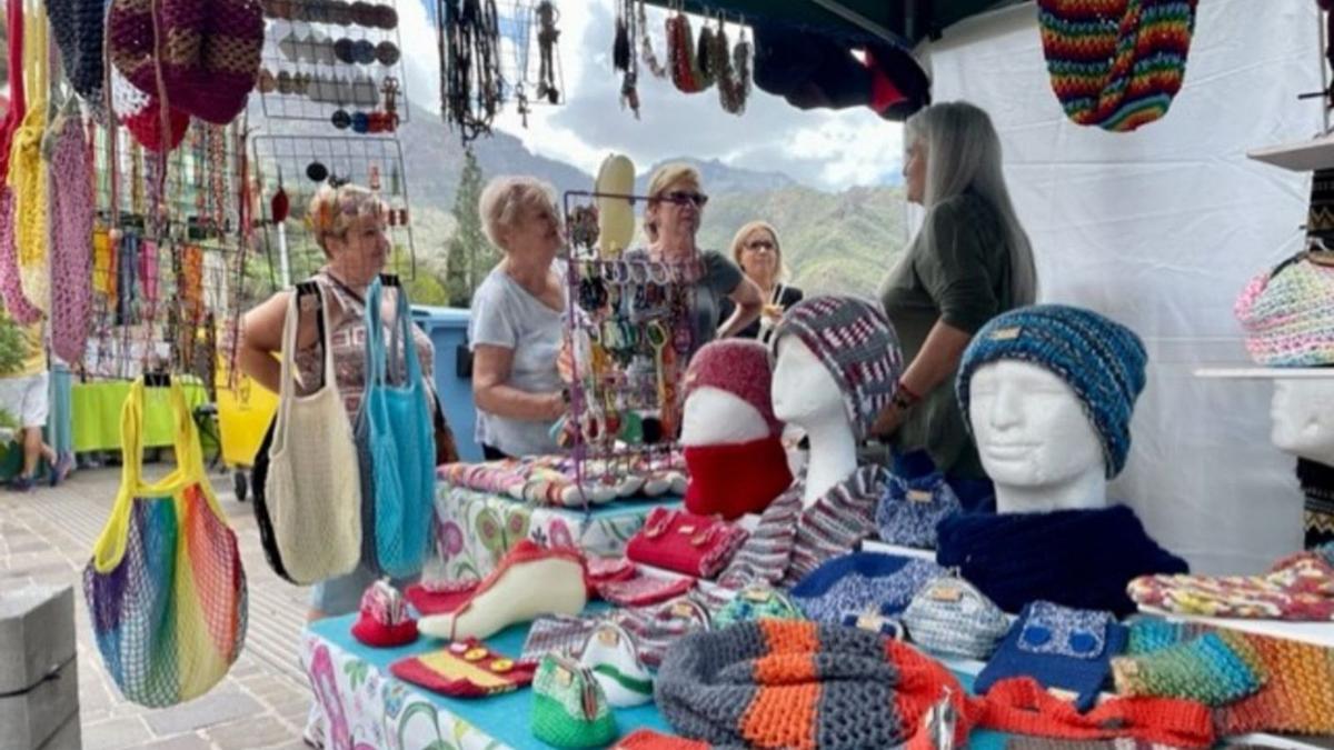 Cuatro visitantes en uno de los puestos ubicados en el centro histórico de Tejeda, ayer, con motivo de la fiesta. . | | LP/DLP