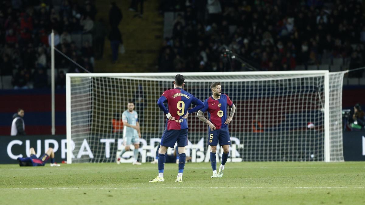 Lewandowski e Iñigo Martínez, apesadumbrados tras el gol de Sorloth en el tiempo añadido que le dio el triunfo al Atlético sobre el Barça en Montjuïc.