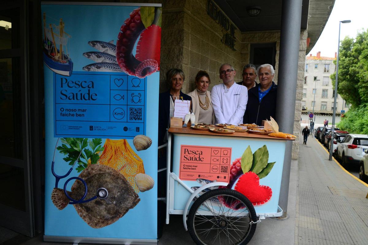 Gustavo Soliño "Guti"(centro)  en el puesto de pinchos de mar en la entrada al centro de salud de Cangas.
