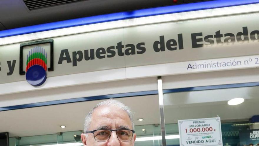 El lotero José Manuel Díaz, muestra el cartel del premio.