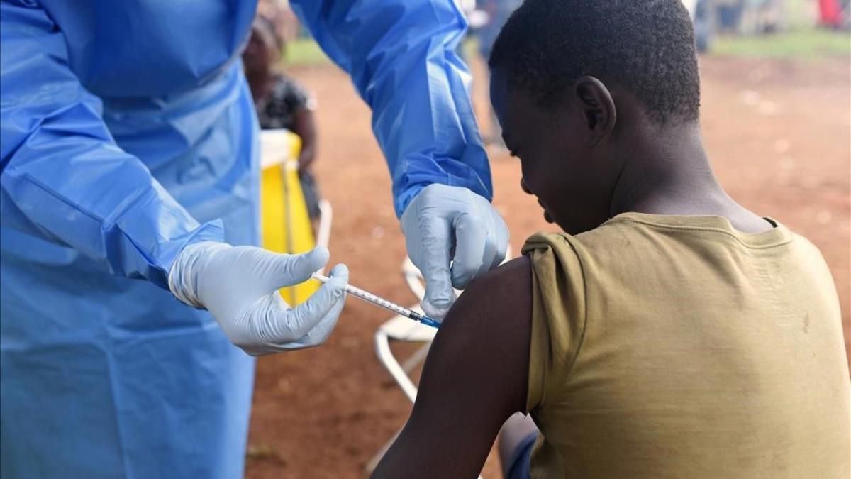 Un joven es vacunado contra el ébola por un médico congoleño.