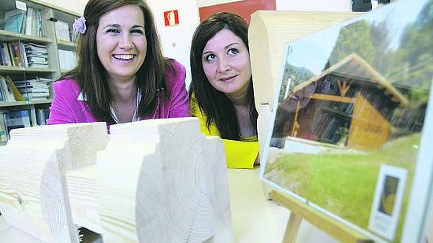 Sara del Cid y Lara María Cepa, en La Curtidora, tras unos perfiles y una reproducción de una cabaña de madera.